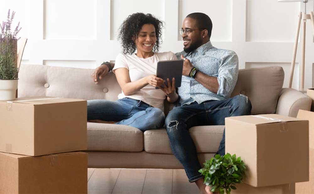 Couple Looking Up Mortgages for First Time Buyers On Couch